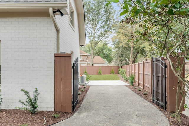 view of property exterior with cooling unit, a patio area, and a yard