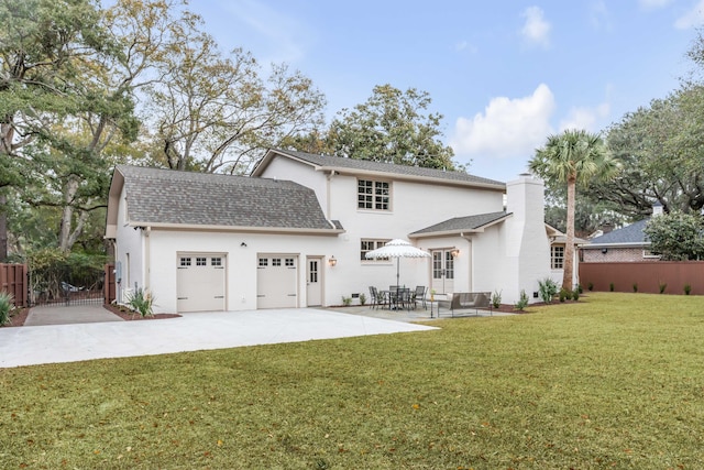 back of house featuring a yard, a patio, and a garage