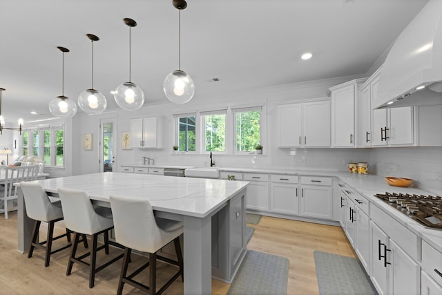 kitchen with stainless steel appliances, premium range hood, white cabinetry, tasteful backsplash, and recessed lighting