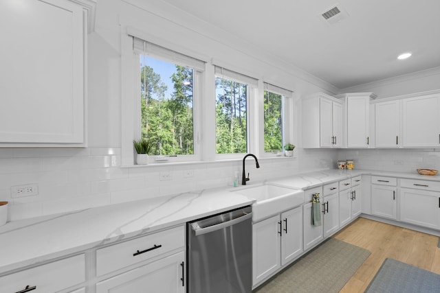 kitchen featuring stainless steel dishwasher, a sink, healthy amount of natural light, white cabinets, and ornamental molding