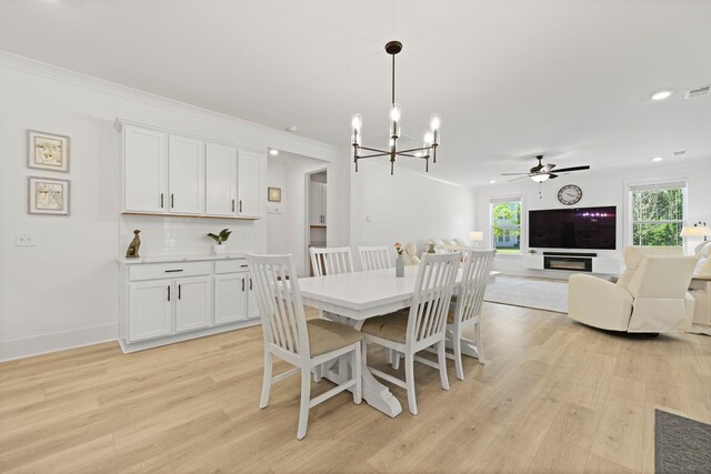 dining space with light wood finished floors, a chandelier, ceiling fan, recessed lighting, and baseboards