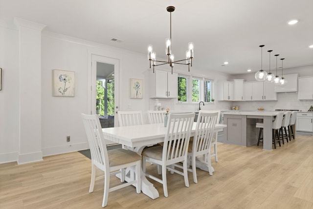 dining space with light wood-style flooring, recessed lighting, crown molding, a chandelier, and baseboards