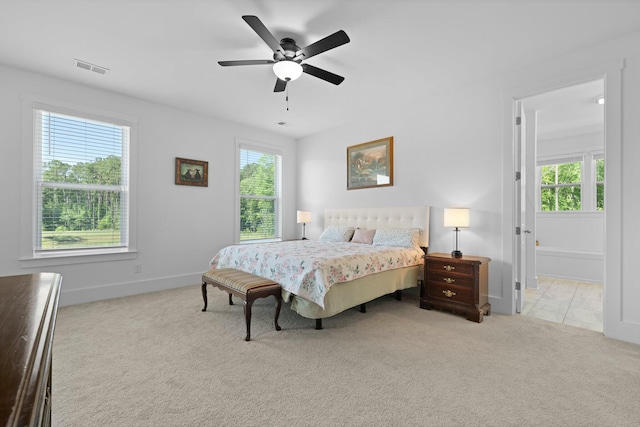 carpeted bedroom with multiple windows, ceiling fan, and baseboards