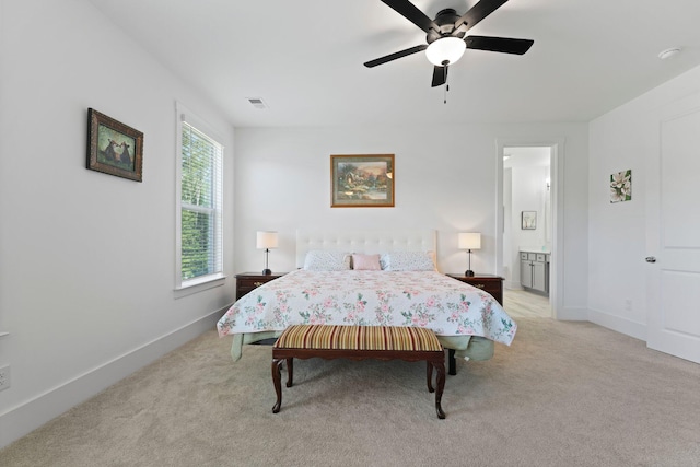 bedroom featuring light carpet, baseboards, ceiling fan, and connected bathroom