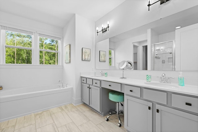 full bathroom with a stall shower, double vanity, and a bath
