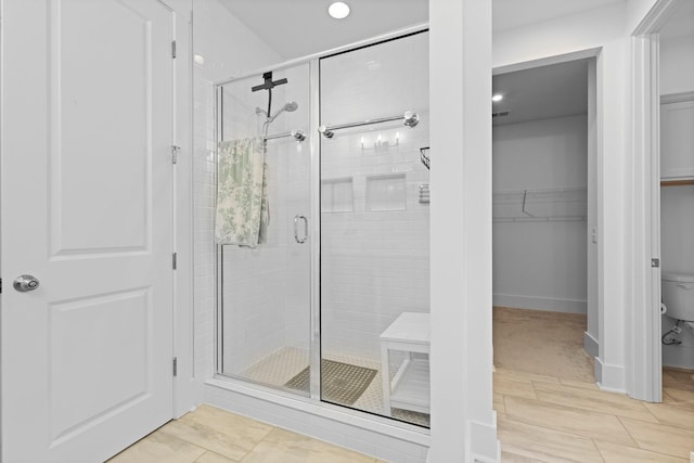 full bath featuring a shower stall, toilet, a spacious closet, and recessed lighting