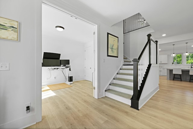 stairway featuring wood finished floors, baseboards, and recessed lighting