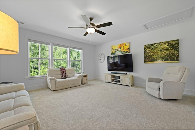 carpeted living room featuring ceiling fan and baseboards