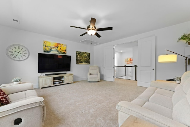 living area featuring ceiling fan, attic access, carpet flooring, and baseboards
