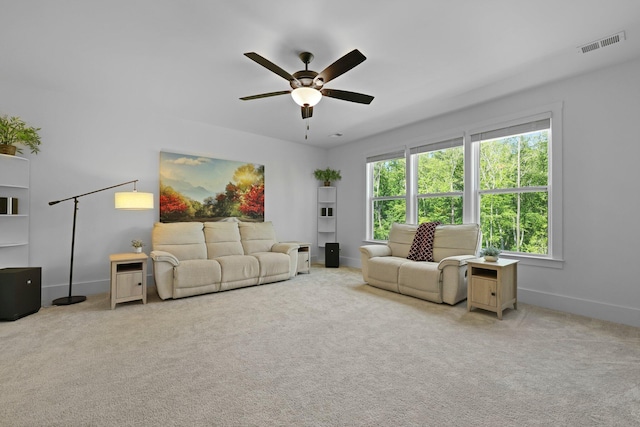 carpeted living room featuring ceiling fan and baseboards