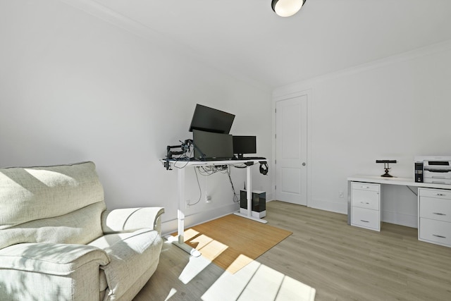 home office with light wood-style flooring, baseboards, and crown molding