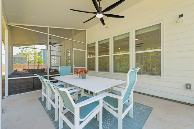 sunroom / solarium with a ceiling fan and outdoor dining space