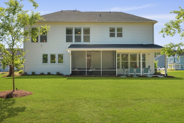 back of house with a yard, a sunroom, and a shingled roof