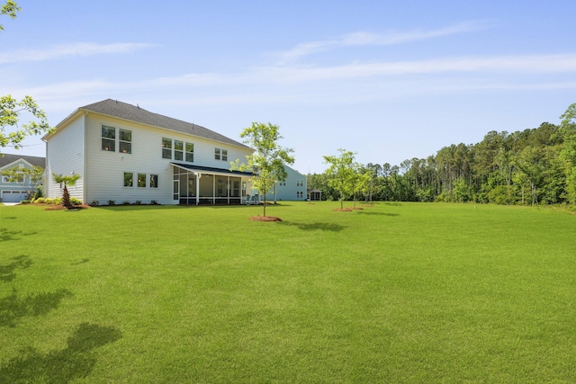 back of house featuring a sunroom and a lawn