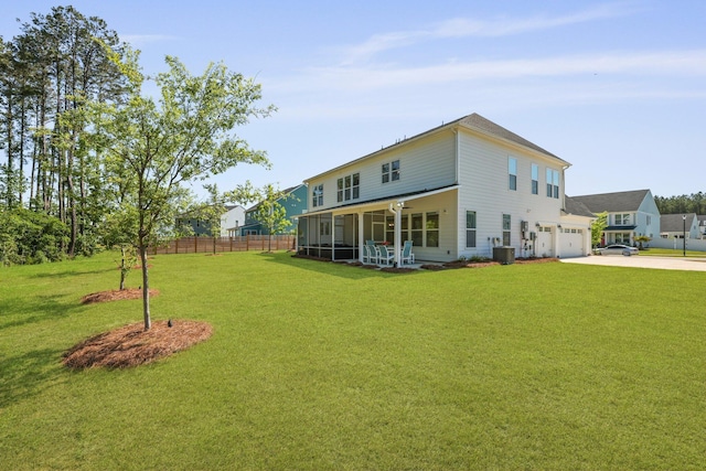rear view of house with concrete driveway, central AC unit, a garage, and a sunroom