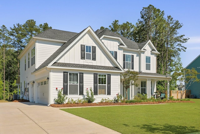 view of front of property featuring an attached garage, board and batten siding, a front yard, and driveway