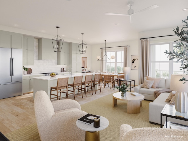 living room with light hardwood / wood-style floors and ceiling fan with notable chandelier