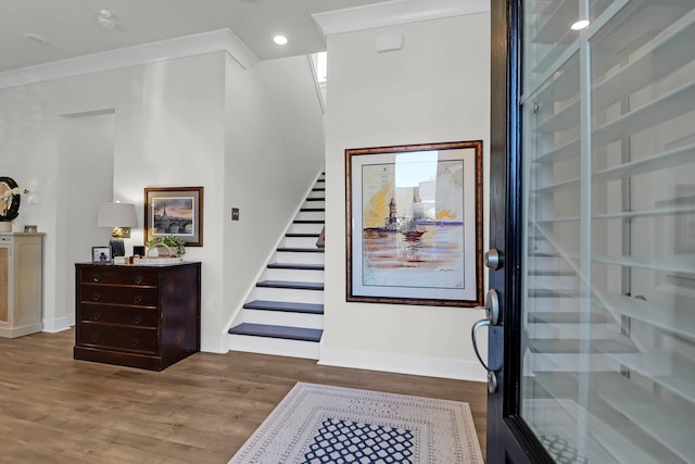 foyer with hardwood / wood-style flooring and crown molding