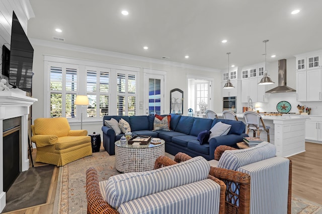 living room featuring crown molding and light wood-type flooring