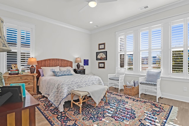 bedroom featuring crown molding, wood-type flooring, and ceiling fan