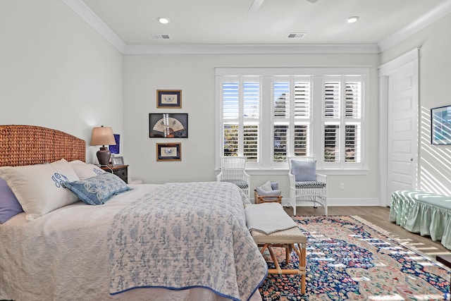 bedroom featuring hardwood / wood-style flooring, ceiling fan, and ornamental molding