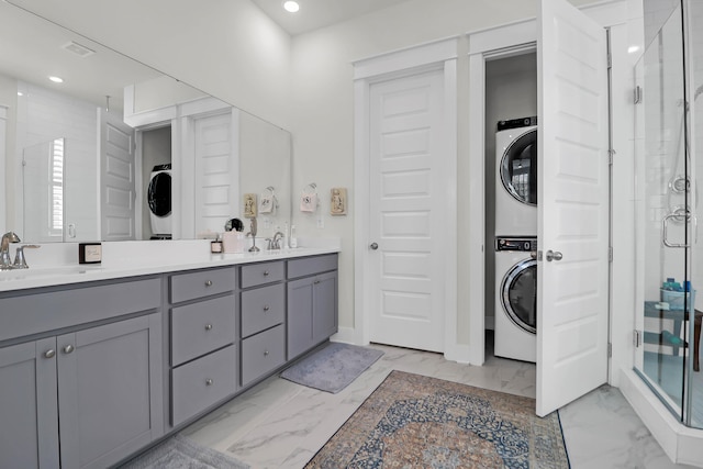 bathroom with stacked washer and dryer, vanity, and walk in shower