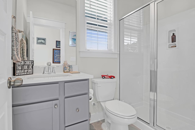 bathroom with vanity, a shower with shower door, and toilet