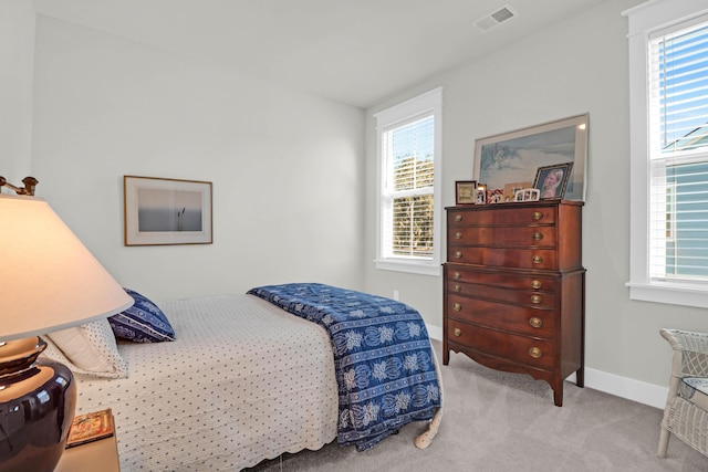 bedroom featuring multiple windows and light carpet