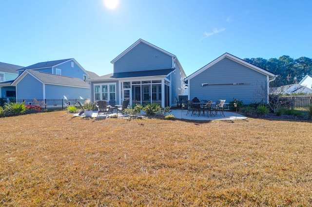 rear view of property with a patio area, a sunroom, and a lawn