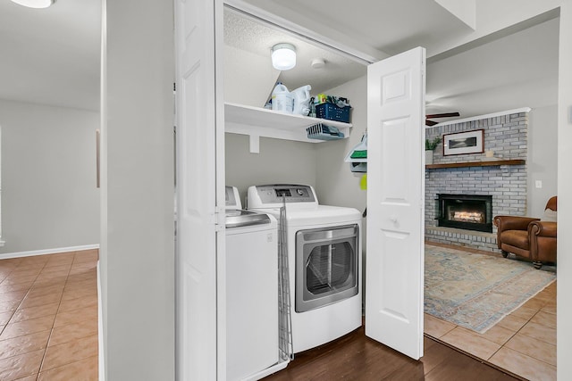 1433 Oaklanding Rd, Mount Pleasant, SC 29464 - laundry area featuring washing machine and dryer, ceiling fan, a brick fireplace, and tile patterned flooring