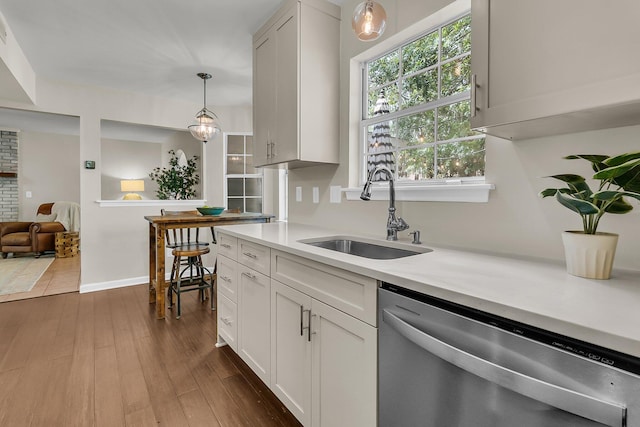 1433 Oaklanding Rd, Mount Pleasant, SC 29464 - kitchen with stainless steel dishwasher, light countertops, hanging light fixtures, white cabinetry, and dark wood-style flooring