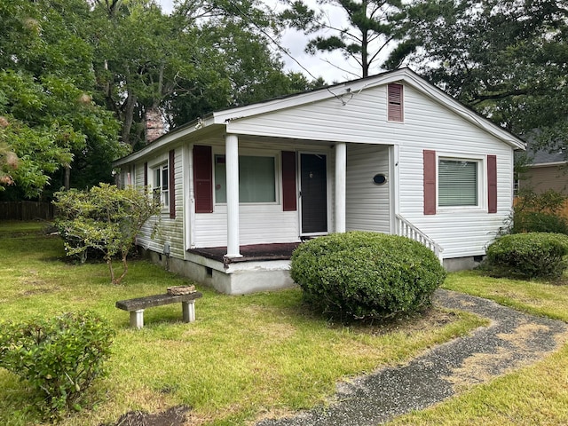 view of front of property featuring covered porch and a front lawn