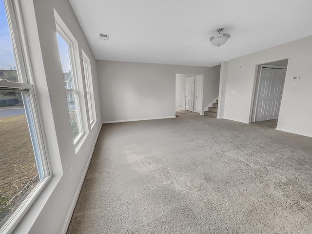 carpeted spare room featuring plenty of natural light