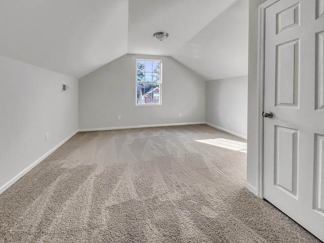 bonus room featuring lofted ceiling and light colored carpet