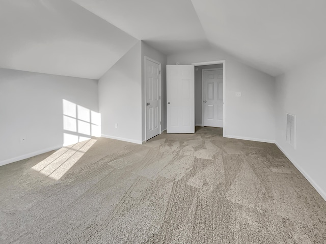 bonus room with light carpet and lofted ceiling