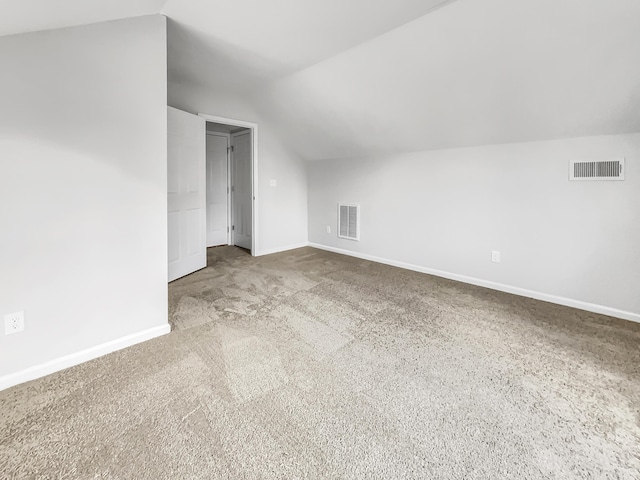 bonus room with light carpet and lofted ceiling