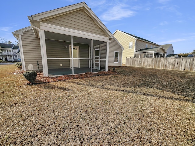 back of house with a yard and a sunroom