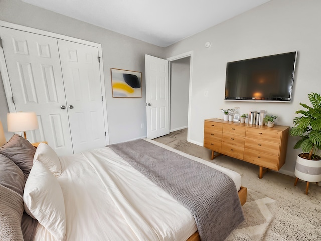 bedroom featuring light carpet and a closet