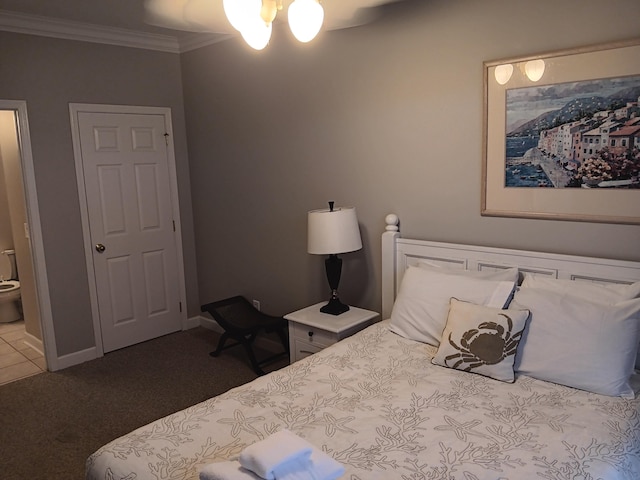 carpeted bedroom with connected bathroom, ornamental molding, and ceiling fan