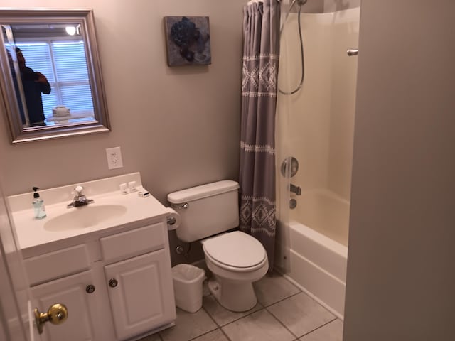 full bathroom featuring tile flooring, toilet, large vanity, and shower / tub combo