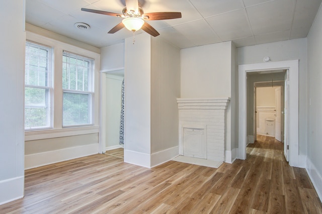 unfurnished living room featuring a fireplace, ceiling fan, and hardwood / wood-style floors