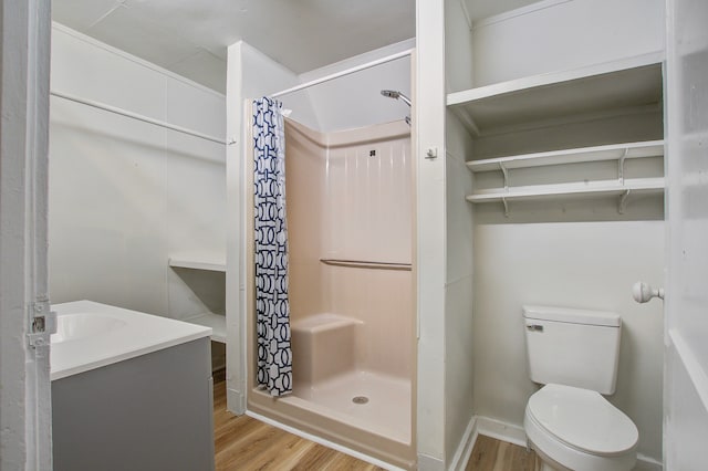 bathroom featuring toilet, wood-type flooring, and walk in shower