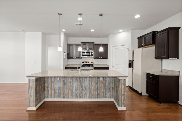 kitchen featuring visible vents, dark wood finished floors, an island with sink, appliances with stainless steel finishes, and a sink