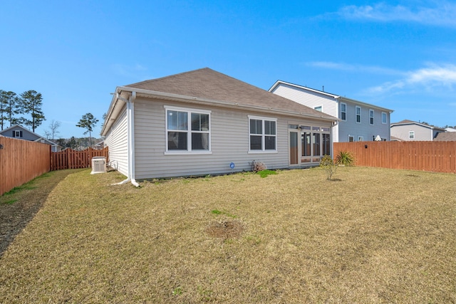 rear view of property with a lawn and a fenced backyard