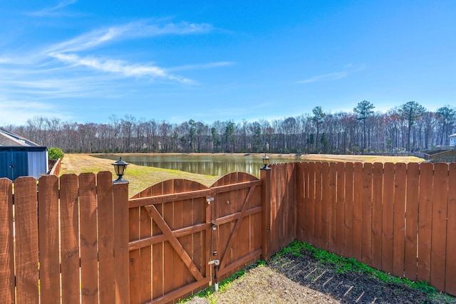 view of gate featuring a water view and fence