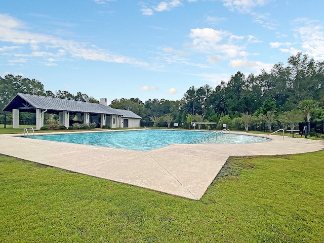 pool featuring a lawn and a patio area