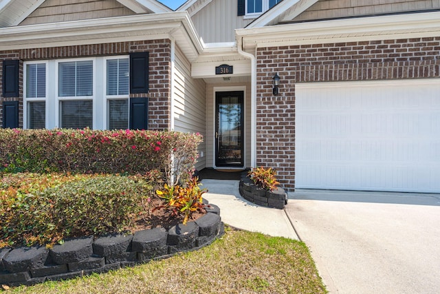 view of exterior entry with a garage, brick siding, board and batten siding, and concrete driveway