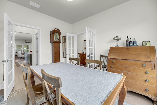 dining area featuring french doors, a ceiling fan, and light wood-style floors