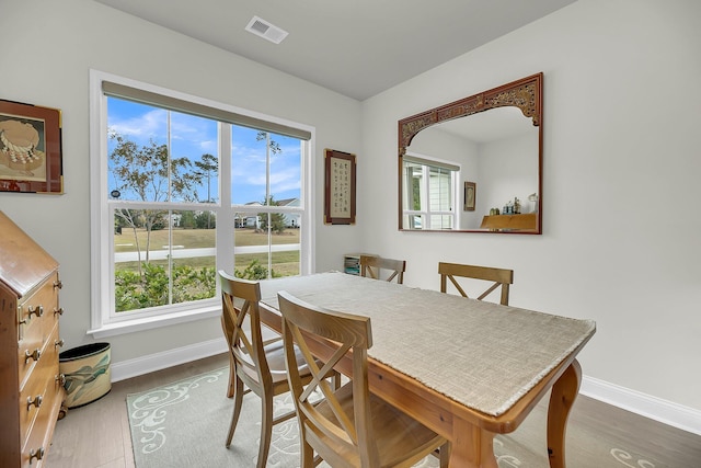 dining room with wood finished floors, visible vents, and baseboards