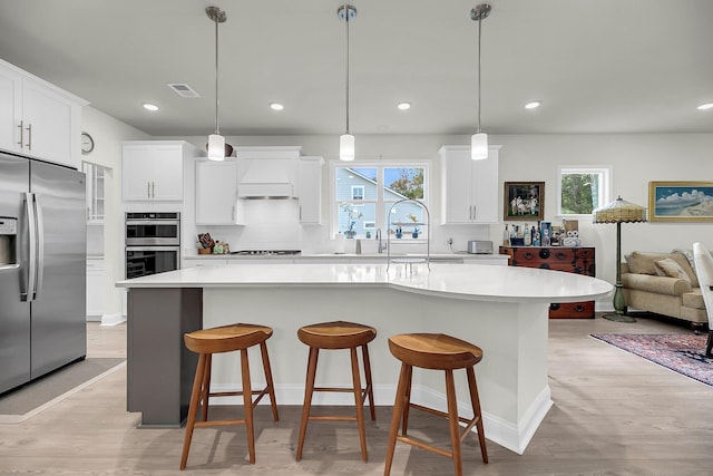 kitchen featuring visible vents, light countertops, appliances with stainless steel finishes, custom exhaust hood, and decorative backsplash